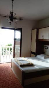a bedroom with a bed and a large window at Apartments Branko in Nin