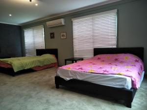 弗兰克斯顿6间卧室/9床大型度假屋|城市+公园美景|海滩的一间卧室配有两张带粉红色床单的床