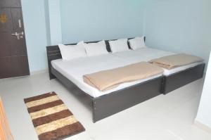 1 cama con sábanas blancas y almohadas en una habitación en SriPaadha Inn Kanipakam en Kanipakam