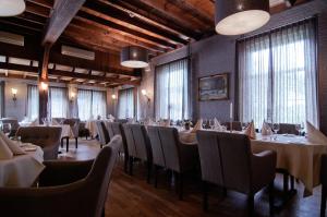 a dining room with tables and chairs and windows at Het Ros van Twente in De Lutte