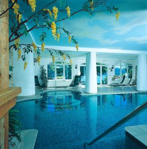 una piscina en una casa de agua azul en Hotel des Alpes, en Molveno