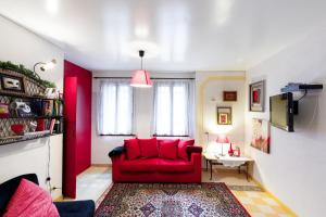 czerwona kanapa w salonie z czerwoną ścianą w obiekcie Valentina's Home w Wenecji