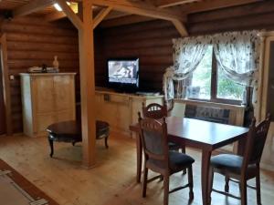 a dining room with a table and chairs and a television at Rancho 555 in Uzhhorod