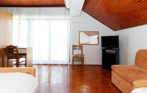 ein Wohnzimmer mit einem Sofa und einem TV in der Unterkunft Motel "Tri lovca" in Knin