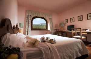 a bedroom with a bed with a window and a desk at La Tenuta Dei Ciclamini in Avigliano