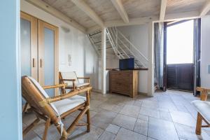 a living room with chairs and a tv and stairs at Appartamento Selene in Monopoli