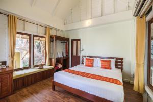 a bedroom with a large bed with orange pillows at Cocohut Beach Resort Koh Phangan in Haad Rin