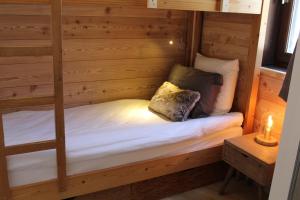 モンジェネヴルにあるLa Chamoisiere Montgenevreの二段ベッド(キャンドル付)が備わる木造の客室です。