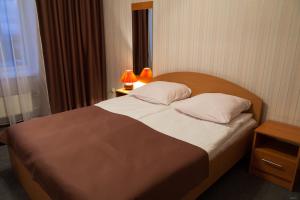 a bedroom with a large bed with two lamps on it at Spasskaya Hotel in Vologda
