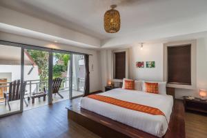 a bedroom with a large bed and a balcony at Cocohut Beach Resort Koh Phangan in Haad Rin