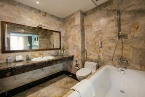 ein Badezimmer mit Badewanne, Toilette und Waschbecken in der Unterkunft Hanoi Pearl Hotel in Hanoi + 129 Fotos