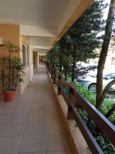a hallway of a building with a fence and trees at Flat 102 in Riviera de São Lourenço