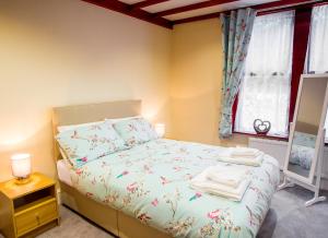 a small bedroom with a bed and a window at Highwood Lodge in Scissett