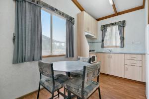 a kitchen with a table and chairs in a room at Australian Community Villages in Bankstown