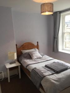 une chambre avec un lit, une lampe et une fenêtre dans l'établissement 4c Belmont Terrace, à Buxton