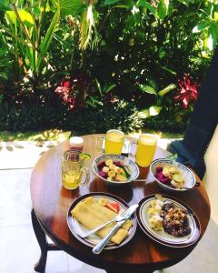une table avec des assiettes de nourriture et des verres de jus d'orange dans l'établissement Pangkung Sari, à Ubud