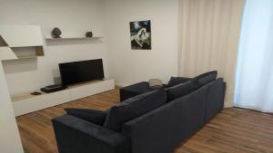 a living room with a black couch and a tv at Funchal Apartment in Funchal
