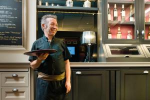 
a man standing in front of a counter in a restaurant at Mercure Toulouse Centre Wilson Capitole in Toulouse
