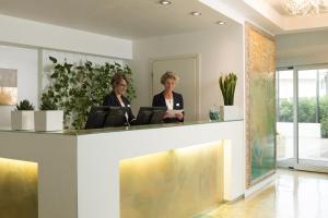 Due donne in piedi davanti a un bancone in una hall di Adriatic Palace Hotel a Lido di Jesolo