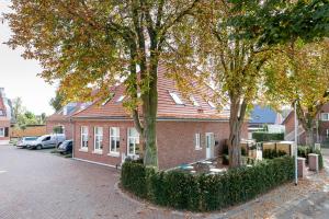 a red brick house with trees in front of it at Apartments LUDGERUSHOF in Bocholt