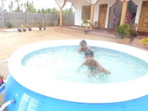 two children swimming in a large swimming pool at Nilaveli Star View Hotel in Nilaveli