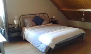 1 dormitorio con 1 cama blanca y 2 mesitas de noche en Chambre d'hotes des Poisets, en Crotenay