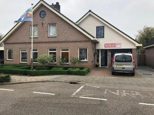 a van parked in a parking lot in front of a house at B & B Nomad in 't Zand