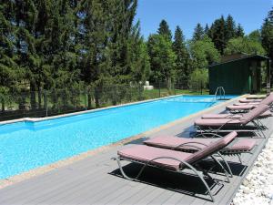 eine Reihe von Liegestühlen neben einem Pool in der Unterkunft Landhotel Rosentaler Hof in Sankt Jakob im Rosental