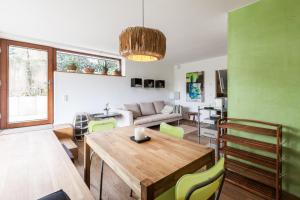 a living room with a wooden table and green walls at Ferienwohnung am Einsteinhaus Caputh in Caputh