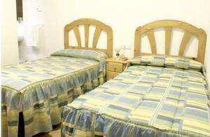 two beds sitting next to each other in a bedroom at Hostal Las Torres in Madrid