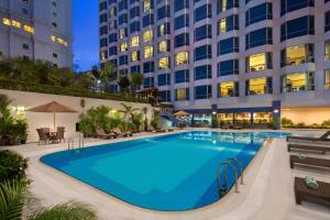 a swimming pool in front of a hotel at night at Millennium Hotel Sirih Jakarta in Jakarta