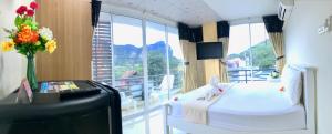 Cette chambre dispose d'un balcon avec un lit et une télévision. dans l'établissement J Apartment, à Ao Nang Beach