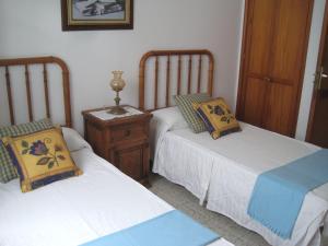 アリエタにあるApartamento en el pueblo de Arrieta 3のベッド2台、ナイトスタンド(2名用)が備わる客室です。