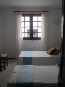 アリエタにあるApartamento en el pueblo de Arrieta 3のベッドルーム1室(ベッド2台、窓付)