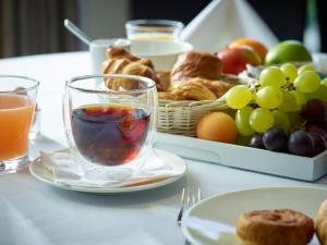 una mesa con un plato de comida y una cesta de fruta en Gosset Hotel, en Groot-Bijgaarden