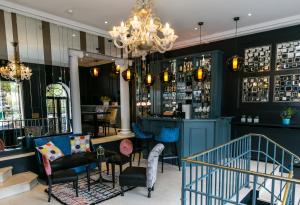 a dining room with a chandelier and a bar at Hotel de Neuville Arc de Triomphe in Paris