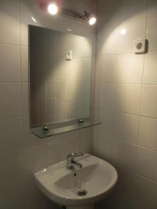 a white sink sitting under a mirror in a bathroom at Hostal Las Torres in Madrid