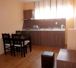 a kitchen with a table and chairs and a sink at Hotel COOP Central in Obzor
