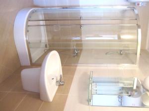 a bathroom with a glass shower and a toilet at Hotel COOP Central in Obzor