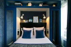 a bedroom with a blue headboard and a bed with pillows at Hotel de Neuville Arc de Triomphe in Paris +29 photos