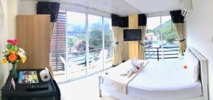 Cette chambre comprend deux lits et une grande fenêtre. dans l'établissement J Apartment, à Ao Nang Beach