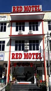 a red motel building with a red motel sign at Red Motel in Nibung Tebal