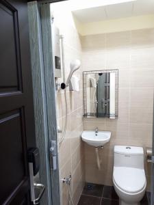 a bathroom with a toilet and a sink and a mirror at Red Motel in Nibung Tebal