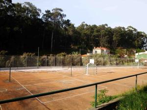 a tennis court with a net on top of it at Parque de Campismo Orbitur Angeiras in Angeiras