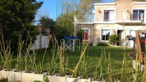 ein Haus mit einem Hof mit hohem Gras in der Unterkunft Nueve Lunas Chascomus in Chascomús