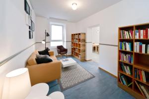 Old Town Hostel في برلين: غرفة معيشة مع أريكة وأرفف كتب