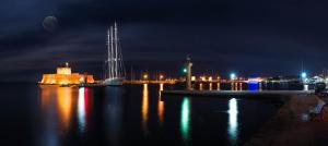 a body of water at night with a city at Lydia Hotel in Rhodes Town