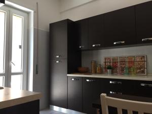ローマにあるBenS' Houses - Villa Pamphili apartmentの黒いキャビネットとテーブル付きのキッチン
