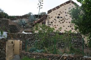 a house with a stone wall and a fence at Casa Rural Poblado Jirdana in La Torre