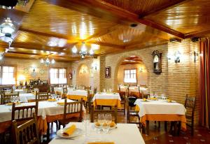 un restaurante con mesas y sillas blancas y una pared de ladrillo en Hospedium Hotel Juan II, en Toro